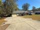 Tan house with gray roof, 2-car garage, and spacious yard at 73 Fir Dr, Ocala, FL 34472