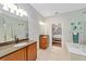 Bathroom with double vanity, soaking tub and view into bedroom at 7358 Sw 101St Ave, Ocala, FL 34481
