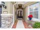 Front entry with stonework, red flowers, and a welcome sign at 7358 Sw 101St Ave, Ocala, FL 34481