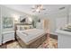 Main bedroom with large bed, ceiling fan, and ensuite bathroom access at 7358 Sw 101St Ave, Ocala, FL 34481