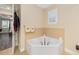 Bathroom featuring a corner soaking tub and a window with plantation shutters at 8160 Sw 92Nd Cir, Ocala, FL 34481