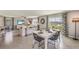 Open dining area with white table, black chairs and view into the living room at 8481 Las Palmas Way, Wildwood, FL 34785