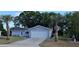 Inviting home featuring a front-entry garage, palm trees, and a tidy, landscaped yard at 8512 Sw 107Th Pl, Ocala, FL 34481