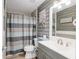 Modern bathroom features a gray vanity, a toilet, a shower with decorative curtain, and unique wood plank accent wall at 8723 Sw 93Rd Ln # C, Ocala, FL 34481