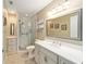 Updated bathroom with a walk-in shower, vanity with quartz countertop, and a large mirror at 8851 Sw 92Nd Pl # E, Ocala, FL 34481