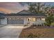Brick ranch home with screened porch, 2-car garage, and mature landscaping at 8851 Sw 92Nd Pl # E, Ocala, FL 34481