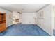 Living room with blue carpet, and view into dining area at 8851 Sw 92Nd Pl # E, Ocala, FL 34481