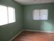 Bedroom with hardwood floors and two windows at 11500 Sw 136Th Pl, Dunnellon, FL 34432