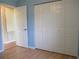 Bedroom with light blue walls, double door closet and wood flooring at 11500 Sw 136Th Pl, Dunnellon, FL 34432