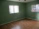 Light green bedroom with hardwood floors and multiple windows at 11500 Sw 136Th Pl, Dunnellon, FL 34432