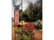 Landscaped front yard with roses, a bench, and American flag at 11500 Sw 136Th Pl, Dunnellon, FL 34432