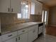 White kitchen with double sink, granite countertops, and dishwasher at 11500 Sw 136Th Pl, Dunnellon, FL 34432