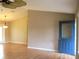 Living room with light walls, laminate flooring and a blue door at 11500 Sw 136Th Pl, Dunnellon, FL 34432