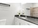 Modern bathroom with dark granite countertop, white cabinets, and decorative plants at 11759 Bostick St, Dunnellon, FL 34432