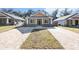 Craftsman style home with gray siding and brick driveway at 11759 Bostick St, Dunnellon, FL 34432