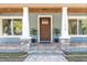 Charming home entrance with a wood door, stone accents, and decorative columns at 11759 Bostick St, Dunnellon, FL 34432