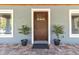 Modern front door with a wood finish and glass panel accents at 11759 Bostick St, Dunnellon, FL 34432