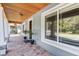 Covered front porch with wood ceiling, stone columns and brick flooring at 11759 Bostick St, Dunnellon, FL 34432