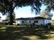 View of the back of the home showing the nice grassy backyard and tree coverage at 13779 Sw 111Th Ave, Dunnellon, FL 34432