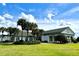 Community clubhouse featuring palm trees, manicured shrubs, and a well-maintained lawn at 13779 Sw 111Th Ave, Dunnellon, FL 34432