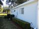 Exterior side view of the home showing the neatly manicured hedge and tidy landscaping at 13779 Sw 111Th Ave, Dunnellon, FL 34432