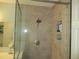 Modern tiled shower featuring glass enclosure and convenient built-in shelving at 13779 Sw 111Th Ave, Dunnellon, FL 34432