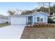 Newly built home with light blue exterior, white garage door, and stone accents at 13824 Se 42 Ave, Summerfield, FL 34491