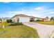 House exterior showcasing a paved driveway and manicured lawn at 13957 Se 86Th Cir, Summerfield, FL 34491