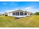 Home exterior showcasing a screened porch and well maintained lawn at 13957 Se 86Th Cir, Summerfield, FL 34491