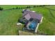Aerial view of house, screened in pool, green yard and fencing at 14130 Sw 8Th Ave, Ocala, FL 34473