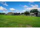 Expansive backyard featuring lush green grass, a barn, and a charming single-Gathering home with a screened-in lanai at 14130 Sw 8Th Ave, Ocala, FL 34473