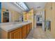 Double vanity bathroom with light wood cabinets and a shower at 14130 Sw 8Th Ave, Ocala, FL 34473