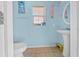 Light blue bathroom with pedestal sink and yellow stool at 14130 Sw 8Th Ave, Ocala, FL 34473