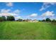 Wide shot of a home with a metal roof and sprawling green lawn under a sunny sky at 14130 Sw 8Th Ave, Ocala, FL 34473
