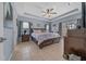 Spacious main bedroom features tile flooring, ceiling fan, and decorative tray ceiling at 14130 Sw 8Th Ave, Ocala, FL 34473