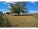 Open pasture with a large tree and distant buildings at 14130 Sw 8Th Ave, Ocala, FL 34473