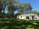 Expansive backyard with lush lawn and mature trees offering a serene outdoor space at 14268 Se 27Th Ct, Summerfield, FL 34491