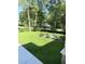 Lush backyard with green grass and mature trees, offering privacy and shade at 14268 Se 27Th Ct, Summerfield, FL 34491