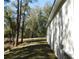 Side yard showing the lush backyard and trees at 14268 Se 27Th Ct, Summerfield, FL 34491