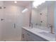Bright bathroom featuring double sinks, quartz countertops, and a glass-enclosed shower at 14268 Se 27Th Ct, Summerfield, FL 34491