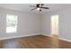 Spacious bedroom with ceiling fan, natural light, and doorway to the bathroom at 14268 Se 27Th Ct, Summerfield, FL 34491