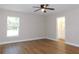 Bright bedroom with wood-look floors, ceiling fan, and access to bathroom at 14268 Se 27Th Ct, Summerfield, FL 34491