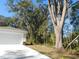 View of the home with a large tree in the front yard, garage and driveway at 14268 Se 27Th Ct, Summerfield, FL 34491