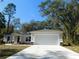 Newly constructed home with a two-car garage and landscaped lawn at 14268 Se 27Th Ct, Summerfield, FL 34491