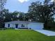 Charming single-story home featuring a well-manicured lawn and an attached two-car garage at 14268 Se 27Th Ct, Summerfield, FL 34491