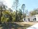 Exterior view of home, landscaped front yard with large trees at 14268 Se 27Th Ct, Summerfield, FL 34491