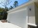 Two car garage door with Craftsman style trim and side lanterns at 14268 Se 27Th Ct, Summerfield, FL 34491