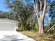 House exterior and driveway with large oak trees at 14268 Se 27Th Ct, Summerfield, FL 34491