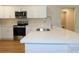 Kitchen features white cabinets, a stainless steel range and microwave, and sleek countertops at 14268 Se 27Th Ct, Summerfield, FL 34491