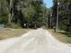 Street view featuring a long unpaved road with mailboxes and wooden street signs at 14268 Se 27Th Ct, Summerfield, FL 34491